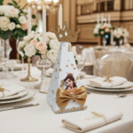Beauty and the Beast pyramid gift box with gold crown, gold bow, and Belle illustration displayed on an elegant wedding-style table.