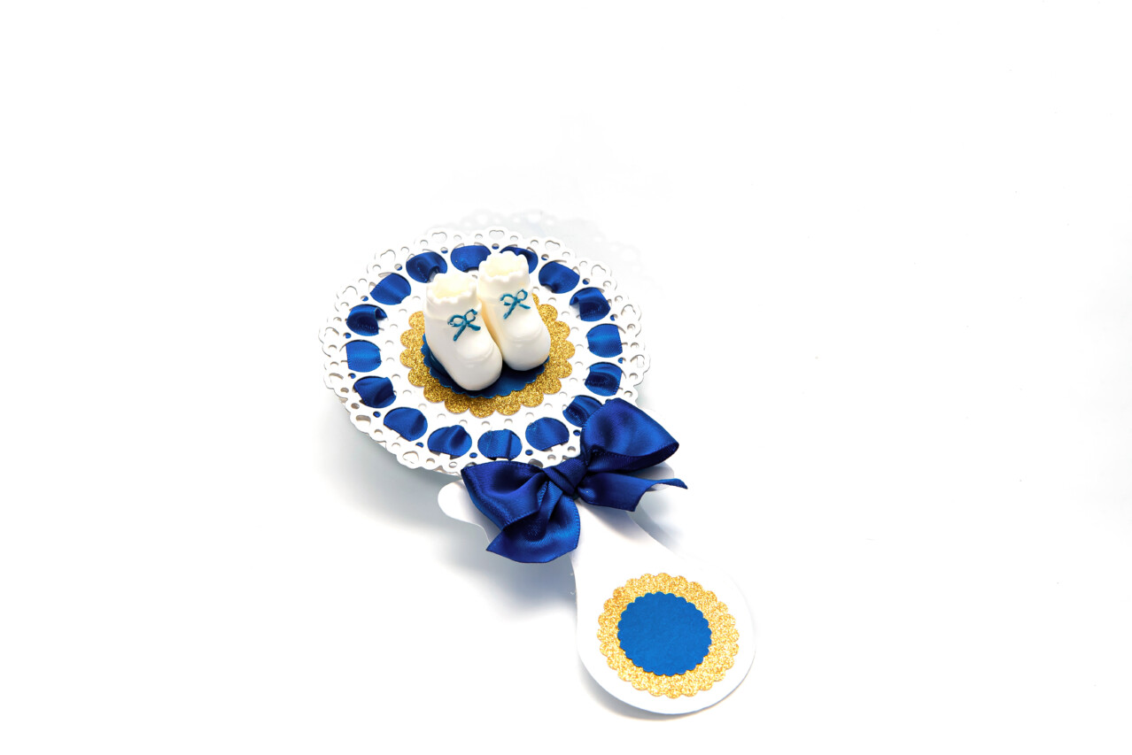 Blue baby Boy shower rattle centerpiece with white baby shoes and gold glitter details