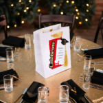 Personalized yellow student graduation favor bags with Class of 2026 cap and tassel displayed on elegant graduation table