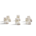 Mini white baby shoes for baby shower crafts and DIY party decorations on pink backdrop