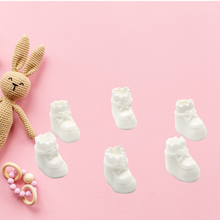 DIY baby shower baby shoes decorations set of six on pink background with nursery accessories