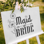Maid of Bride wedding sign printable PNG design displayed on outdoor bridal party welcome board